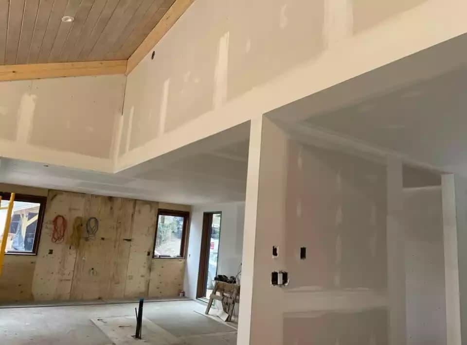 Salon de chalet avec plafond cathédrale en bois et murs fraîchement finis